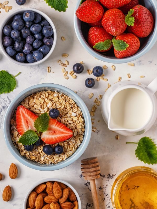 Healthy breakfast - a bowl of oatmeal, berries and fruit, top view.